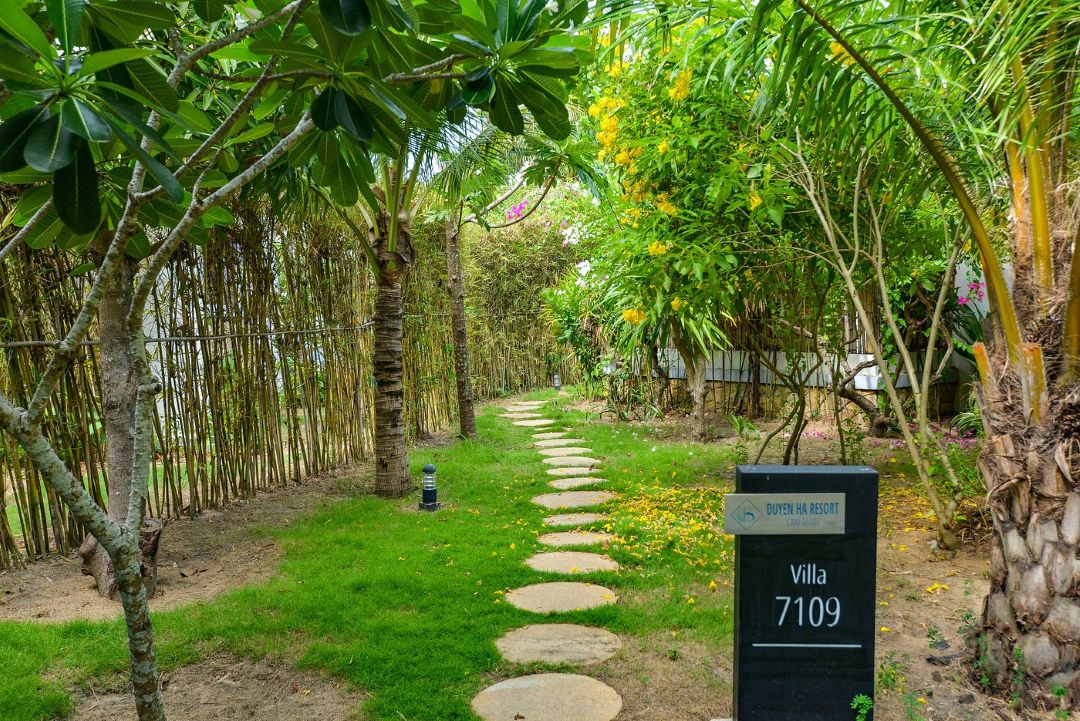 Không gian Duyên Hà Resort Cam Ranh nhiều cây xanh, lối đi trải dài giữa vườn